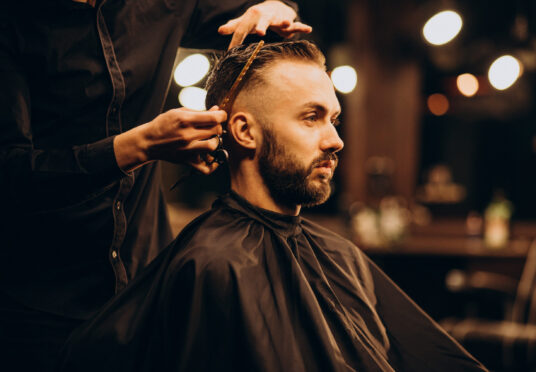 Young man at barbershop trimming hair